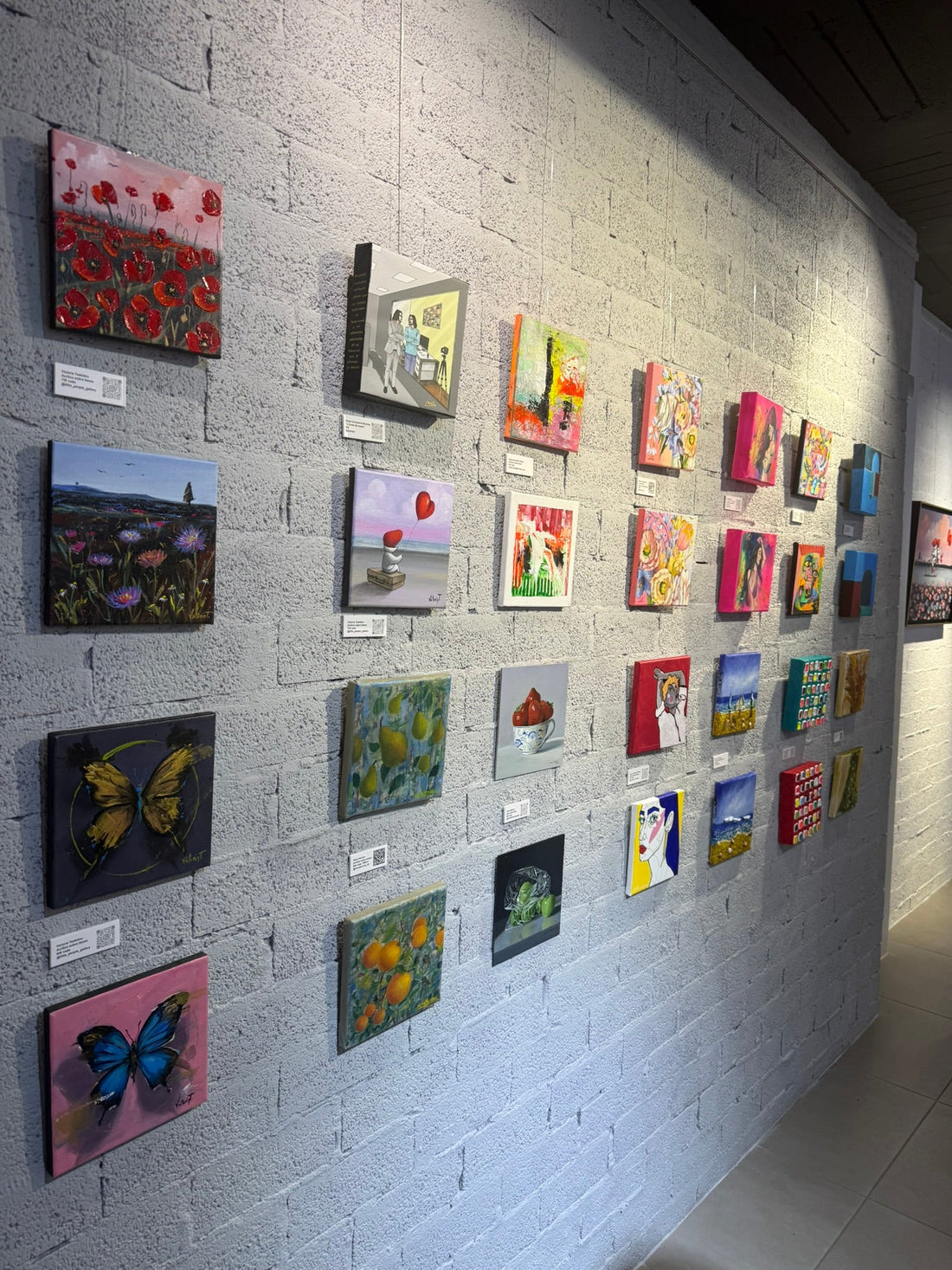 Two small format floral acrylic paintings with pink backgrounds by Maryna Riepnova at Little People Gallery in Málaga.