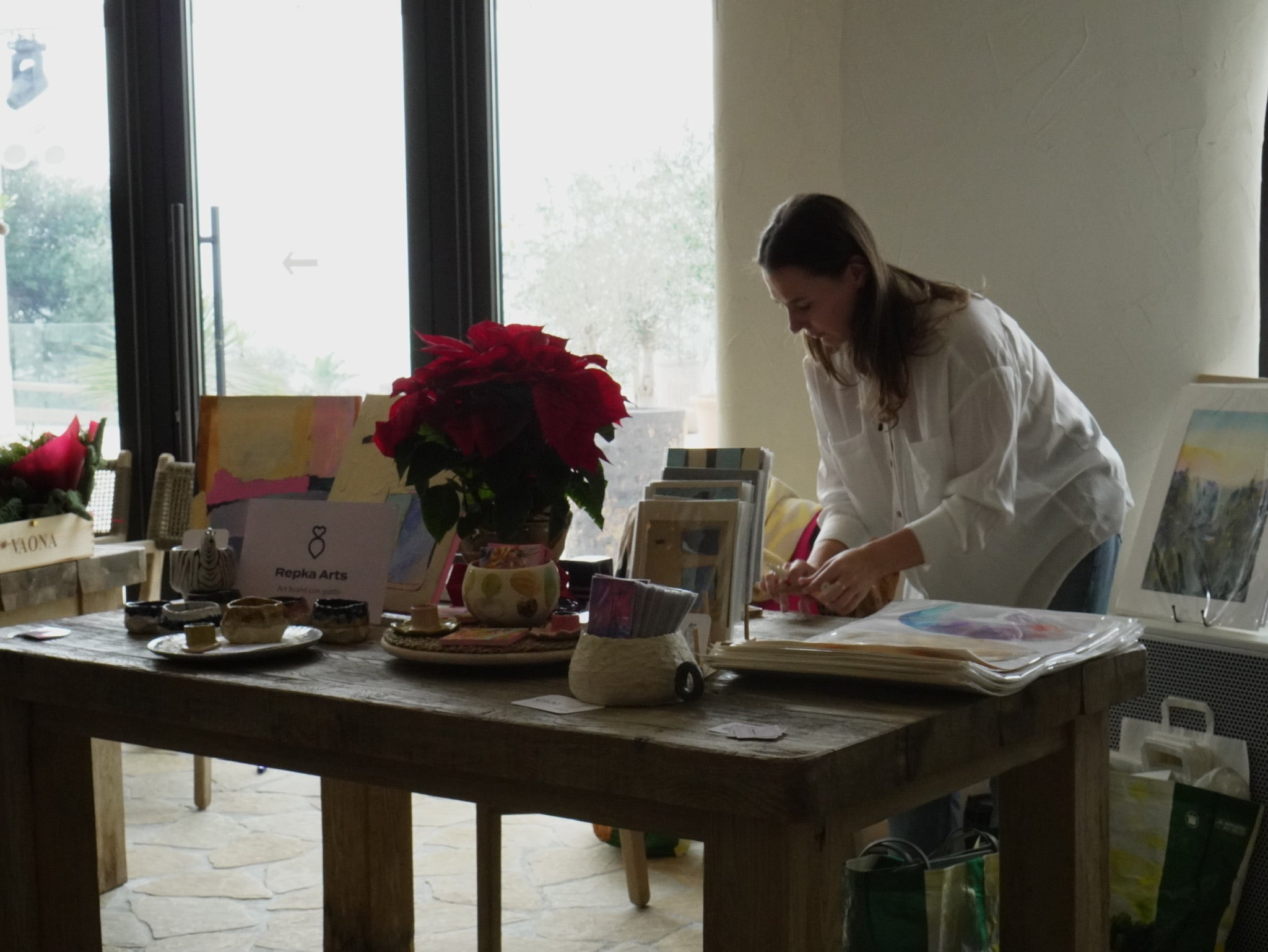 Artist Maryna Riepnova live painting abstract postcards at an event in Estepona